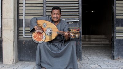 باهي صلاح “فخر الدقي”.. يد تحرس العقار وأخرى تعزف على الأوتار (صور وفيديو)