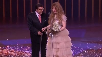 بعكاز.. سمير صبري يسلم جائزة الهرم الذهبي لـ نيللي بالقاهرة السينمائي