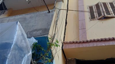 ‎أحد سكان عقار المنصورة المائل: 20 أسرة في الشارع ونطالب بتدخل سريع