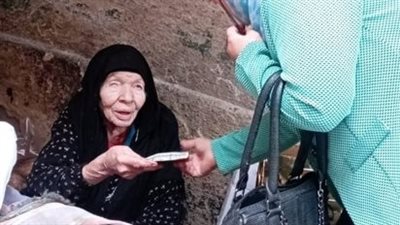 تضامن الجيزة تقدم مساعدات مادية وبطاطين لسيدة تعمل بائعة بشوارع الجيزة | صور
