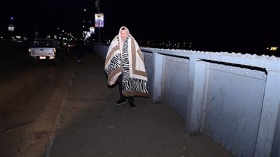 مواطن سوهاجي يتجول في الشوارع مرتديًا بطانية بسبب الطقس السيئ | صور