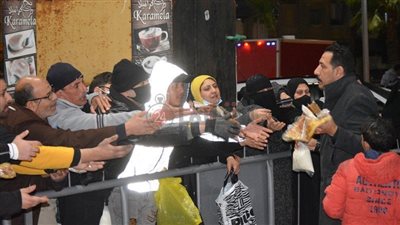 في عز البرد.. شاب يوزع الفطير المشلتت والعسل على البسطاء ببورسعيد | صور وفيديو 