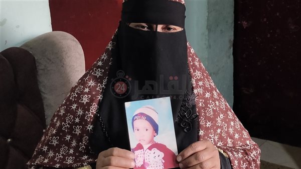 الأم تمسك بصورة طفلها