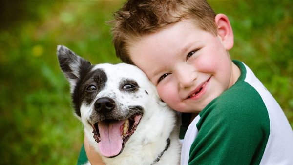 طفل يحتضن كلبا 
