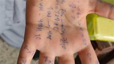 علشان ممنوع ندخل بورقة بيضاء.. طالبة بالصف الأول الثانوي تكتب على يدها لحل مسائل امتحان الكيمياء