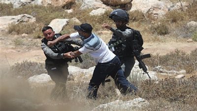 شاب فلسطيني يتبادل اللكمات مع جنود الاحتلال الإسرائيلي خلال الدفاع عن أرضه | صور 