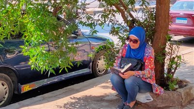 بالمصحف.. سيدة تدعم ابنها أمام لجنة الثانوية العامة في الجيزة