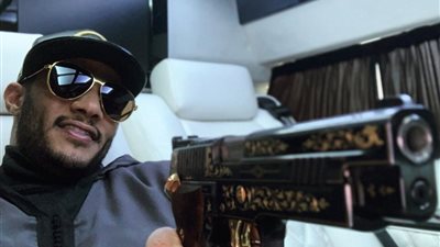 بعد التباهي بالسيارات.. السلاح المرصع بالذهب تيمة فخر محمد رمضان الجديدة (صور)