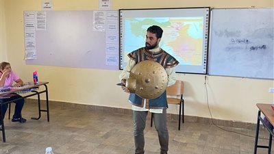 خريج الأزهر.. معلم يرتدي الدرع والخوذة خلال شرح قصة دولة المماليك لمعايشة الطلاب للتاريخ