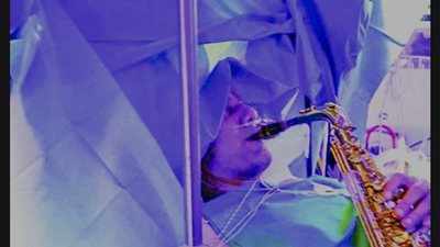 وصلة موسيقية في غرفة العمليات.. مريض يعزف أثناء إجراء عملية جراحية في رأسه