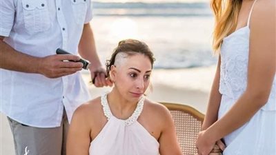 سيدة تتحدى سرطان الثدي فوتوسيشن أثناء حلاقة شعرها (صور)