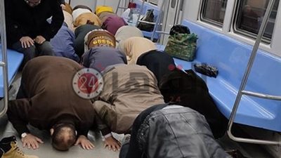 تفاصيل صورة ركاب يؤدون صلاة الفجر داخل عربة مترو متحرك