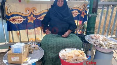 سيدة تفترش رصيف كوبري بأسيوط لبيع الترمس: بكافح من 35 سنة لتربية أولادي| فيديو وصور